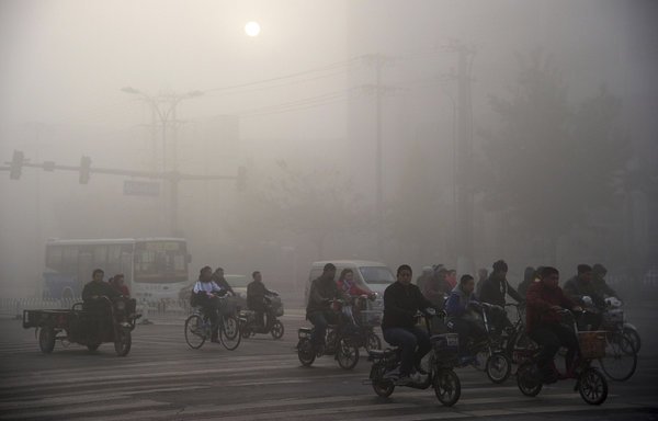 Residents ride bicycles amid heavy haze in Xingtai